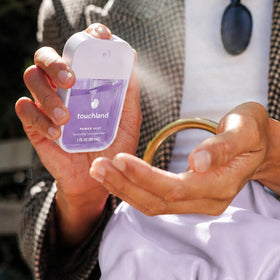 Lifestyle image of Touchland hand sanitizer sprays on a table