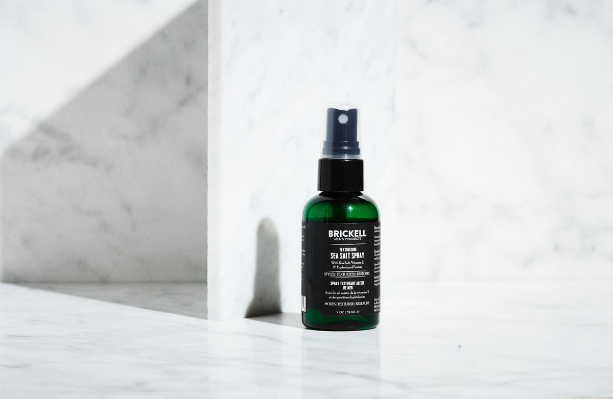 Lifestyle scene of man using Brickell Men's Sea Salt Spray