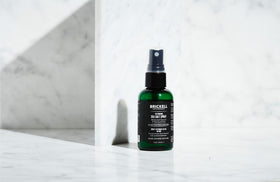 Lifestyle scene of man using Brickell Men's Sea Salt Spray