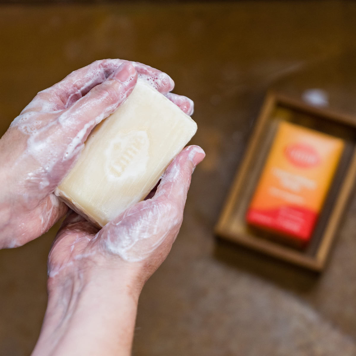 Lume Triple Milled Bar Soap Clean Tangerine lathering on skin