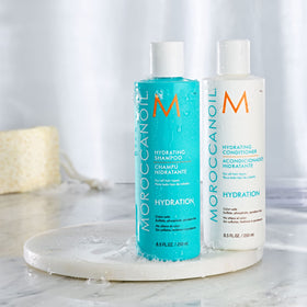 Moroccanoil Hydrating Shampoo with a plant background