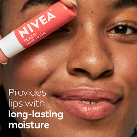 NIVEA Peach Lip Care tinted lip balm on a desk