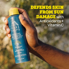 Oars + Alps SPF 50 Body Sunscreen Spray on a beach setting