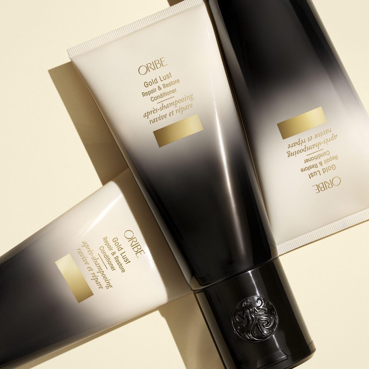 ORIBE Gold Lust Conditioner on a vanity with flowers