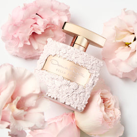 Oscar de la Renta Bella Rosa Eau de Parfum bottle with floral background