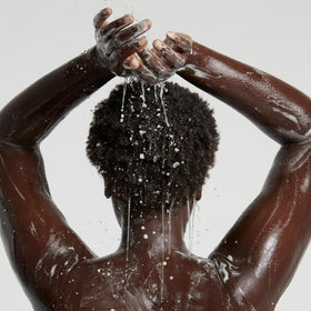 OUAI Body Cleanser lathering on a loofah