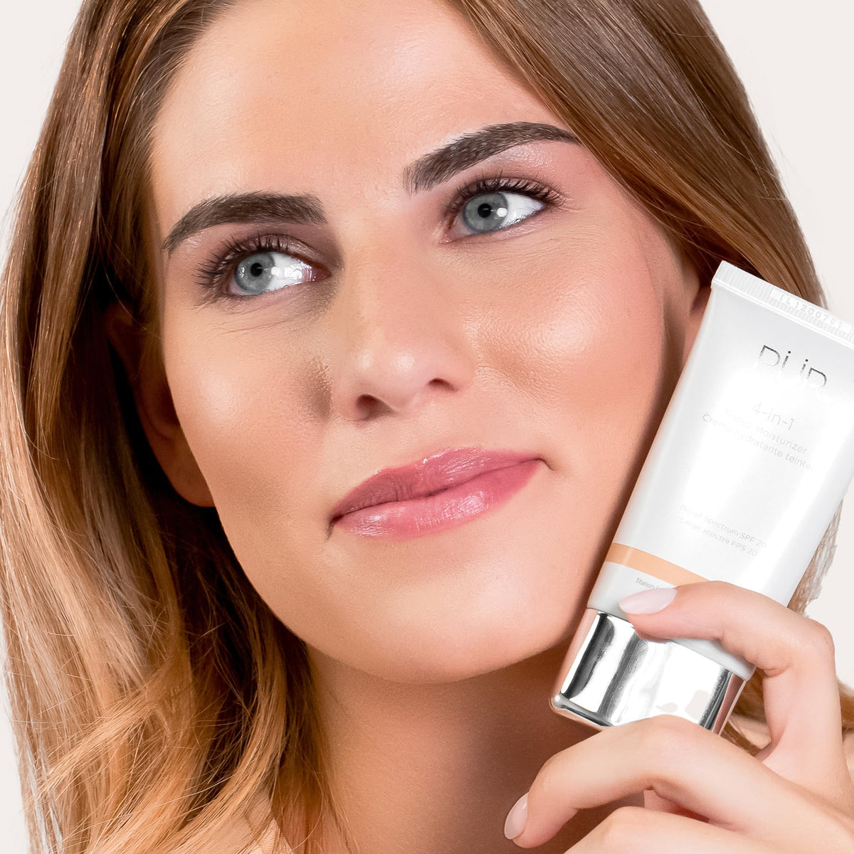 PÜR 4-in-1 Tinted Moisturizer tan shade on a vanity