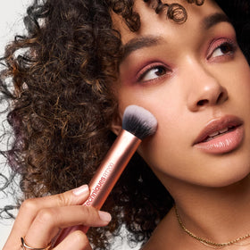 Real Techniques Expert Face Brush being used on a makeup palette