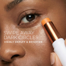 RoC Multi Correxion Eye Balm stick being applied under the eye