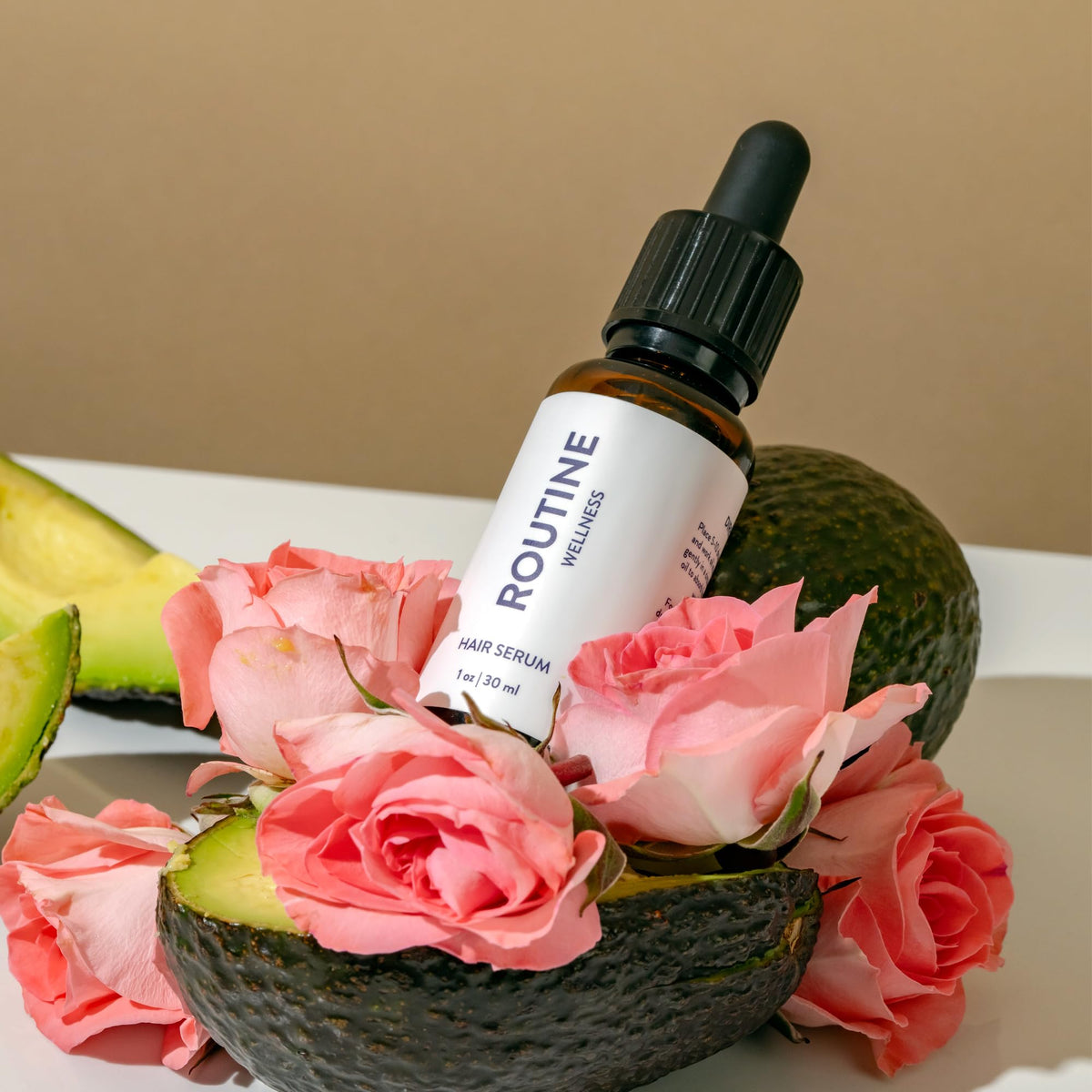 Routine Wellness Hair Serum 30ml bottle with a dropper on a marble background
