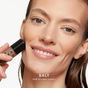 Saie Dew Bronze Liquid Bronzer Stick on a makeup table