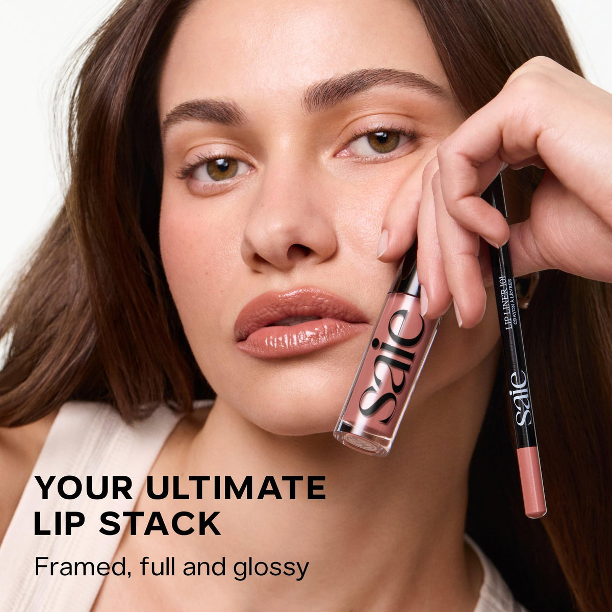 Saie Glossybounce Hydrating Lip Gloss Oil Hybrid on a makeup table