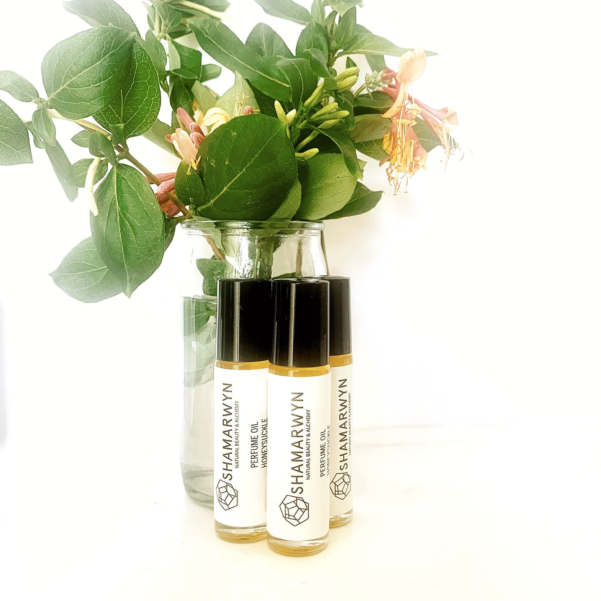 shamarwyn Honeysuckle Perfume Oil roll-on with a floral background