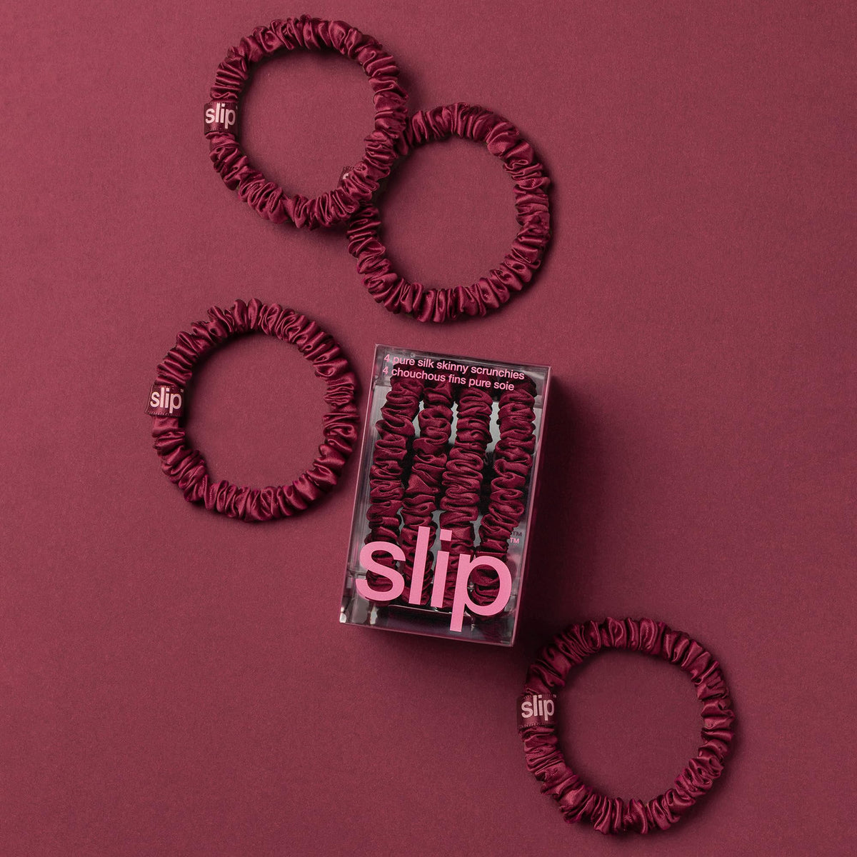 SLIP skinny scrunchies in maroon displayed on a soft surface