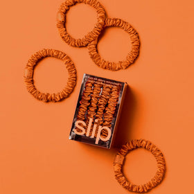 SLIP Skinny Silk Scrunchies displayed with a hairbrush