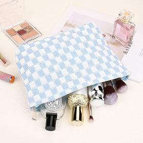 SOIDRAM blue checkered makeup bag in travel setting