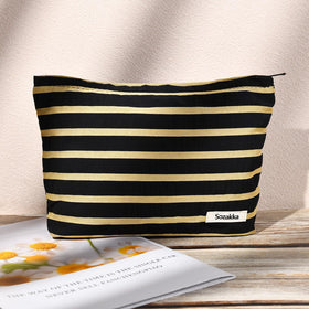 SOIDRAM makeup bag in black and white stripes on a table