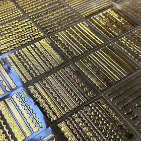 SPLOCUDU gold nail art stickers on a decorated nail