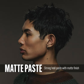STMNT Matte Paste 3.38 oz with a background of styled hair