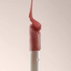 Summer Fridays Dream Lip Oil on a vanity with flowers