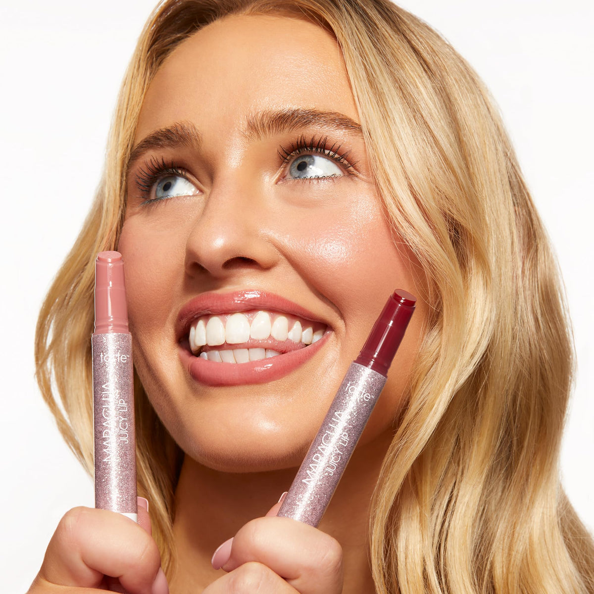 tarte Maracuja Juicy Lip Balm Duo displayed with tropical fruits