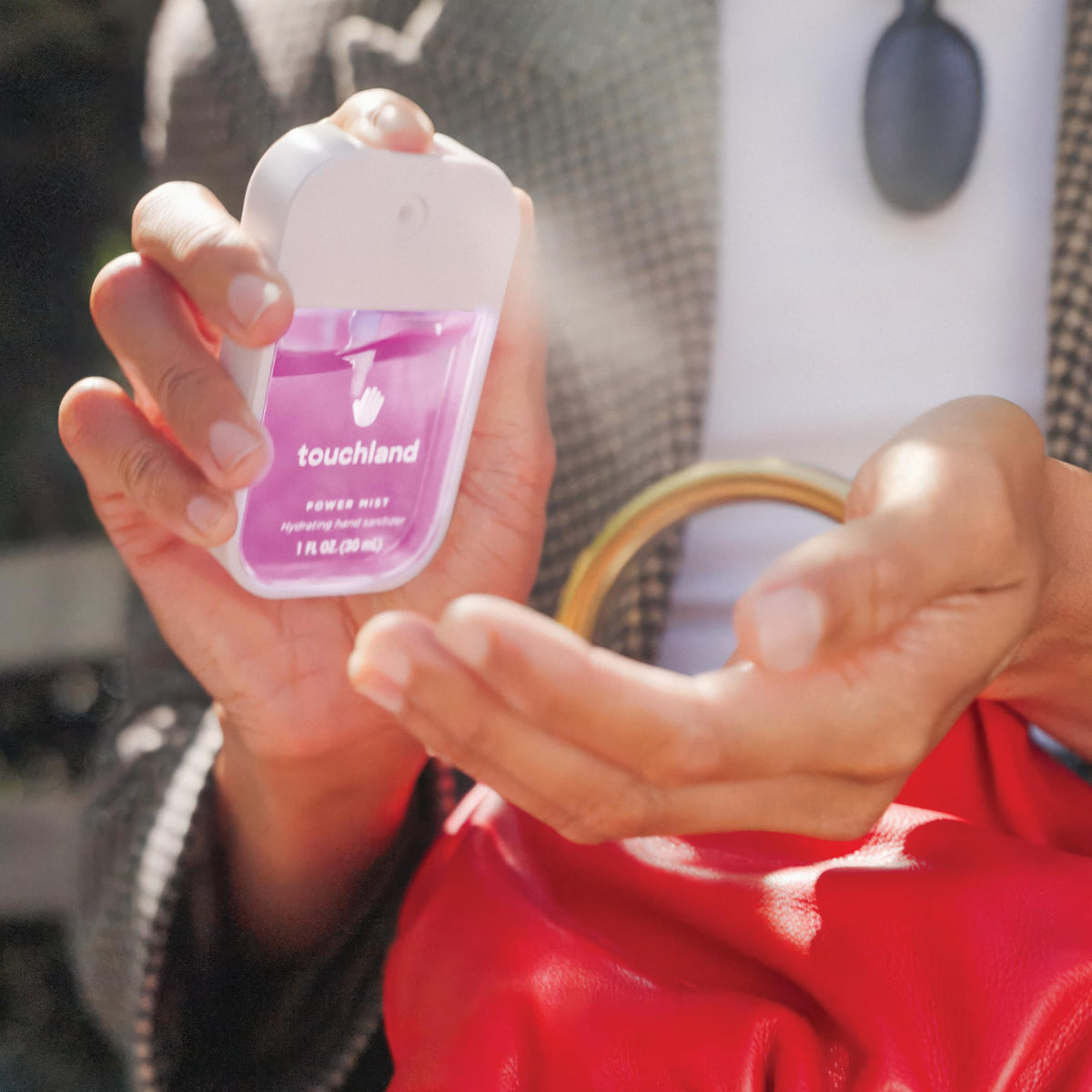 Touchland Juicy 5 Hydrating Hand Sanitizer in use outdoors