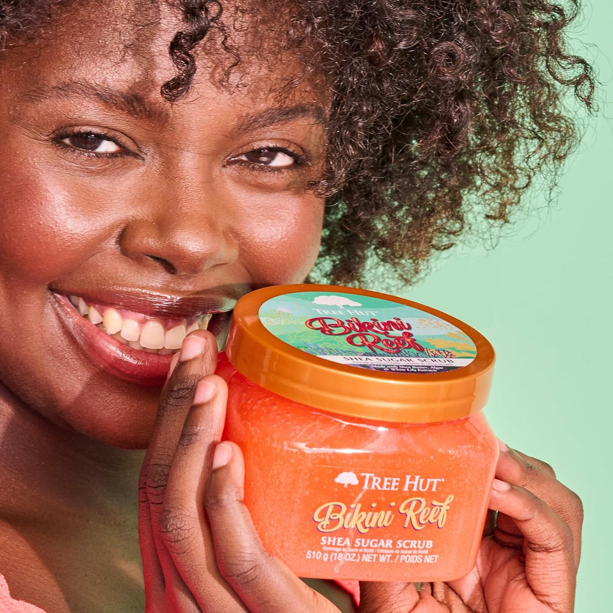 Tree Hut Shea Sugar Scrub Bikini Reef 18 oz with floral background