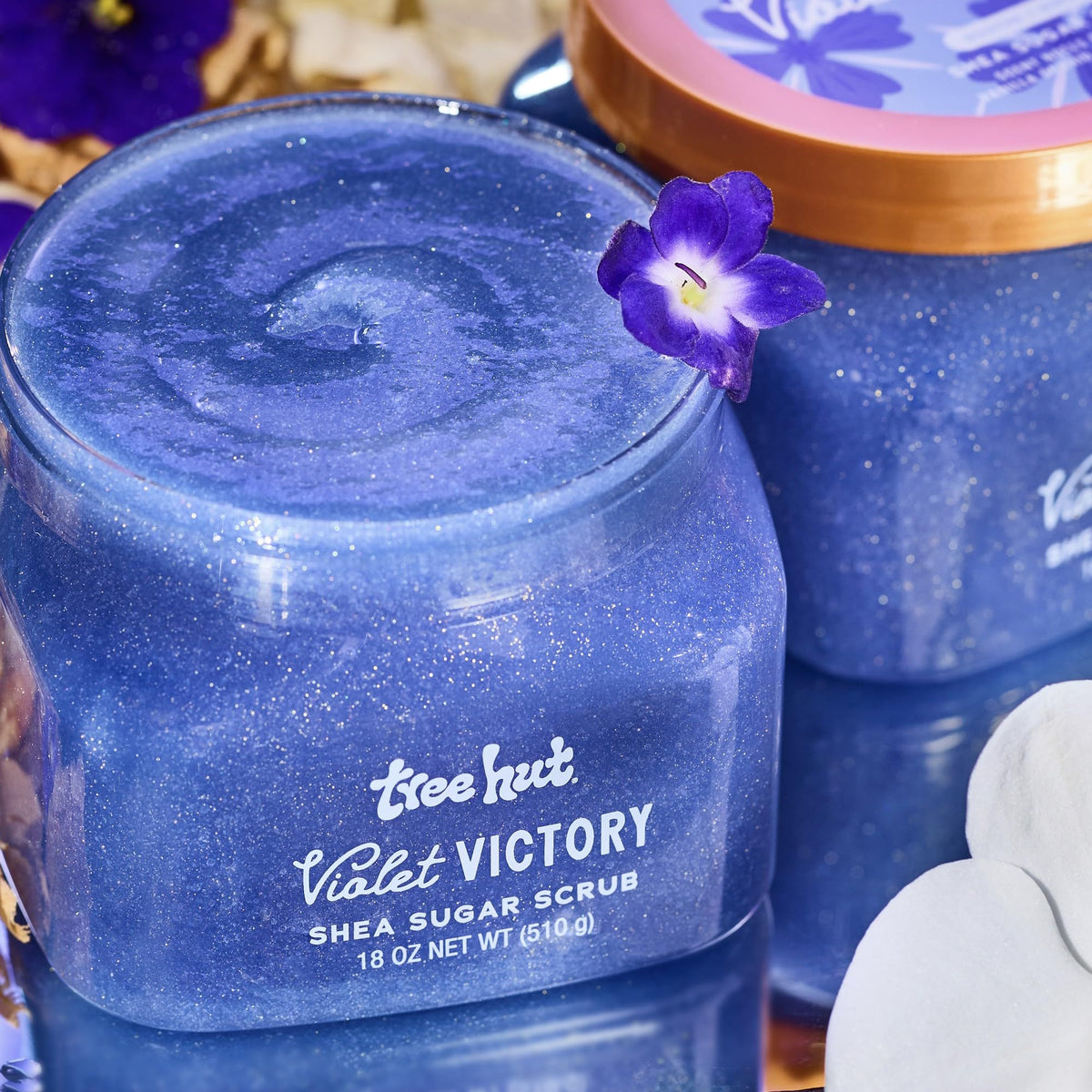 Tree Hut Violet Victory Body Scrub 18 Oz with floral background