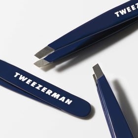 Tweezerman Mini Slant Tweezer Evening Blue in hand for brow shaping