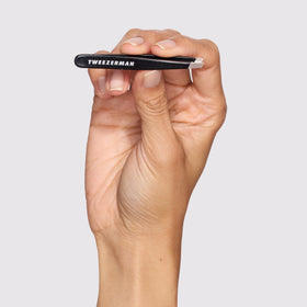 Tweezerman Mini Slant Tweezer held in hand for demonstration