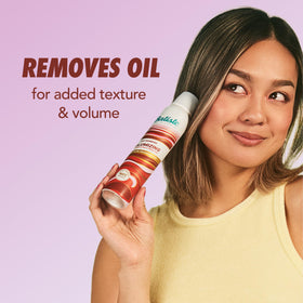 User applying Batiste Dry Shampoo to hair