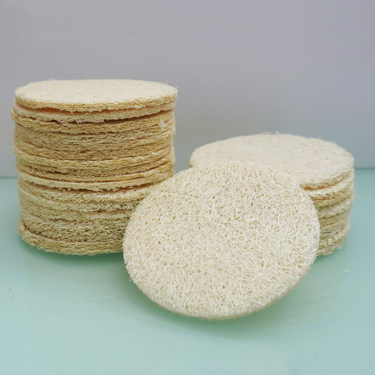 VeridianLife natural loofah face pads next to a cleanser
